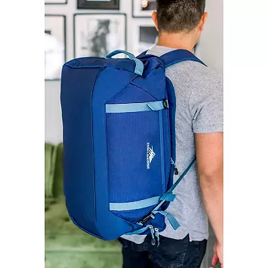 Blue convertible duffel backpack worn as a backpack to demonstrate hybrid functionality