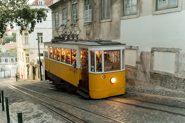 Famous yellow Tram 28 passing through a narrow street in Lisbon’s Alfama district