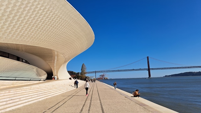 Modern curved building of MAAT on Lisbon’s waterfront with river and promenade